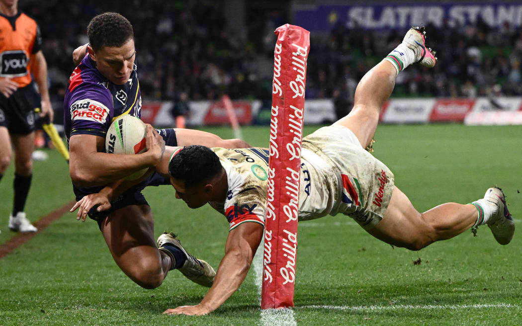 Roger Tuivasa-Sheck of the Warriors (centre) tackles Will Warbrick of the Storm (left) over the sideline during the NRL Round 6 match between the Melbourne Storm and the New Zealand Warriors at AAMI Park.