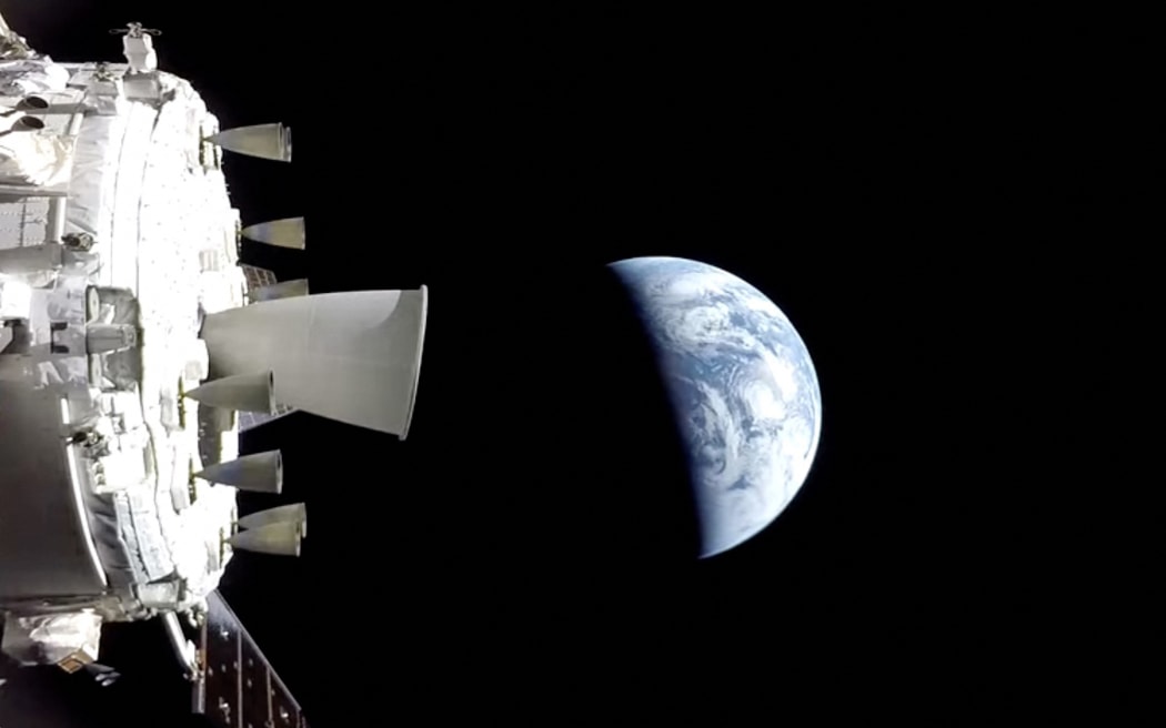 This screengrab from a NASA livestream shows the Orion spacecraft on its way back to the Earth on April 10, 2026. The Artemis II astronauts were preparing April 10 for a high-stakes re-entry and splashdown, the final and perhaps most risky step of their historic 10-day journey around the Moon. Earlier this week, Americans Reid Wiseman, Victor Glover and Christina Koch along with Canadian Jeremy Hansen voyaged further from Earth than any human before in a mission considered a key stepping stone towards eventual crewed lunar landings. (Photo by Handout / NASA / AFP) / RESTRICTED TO EDITORIAL USE - MANDATORY CREDIT