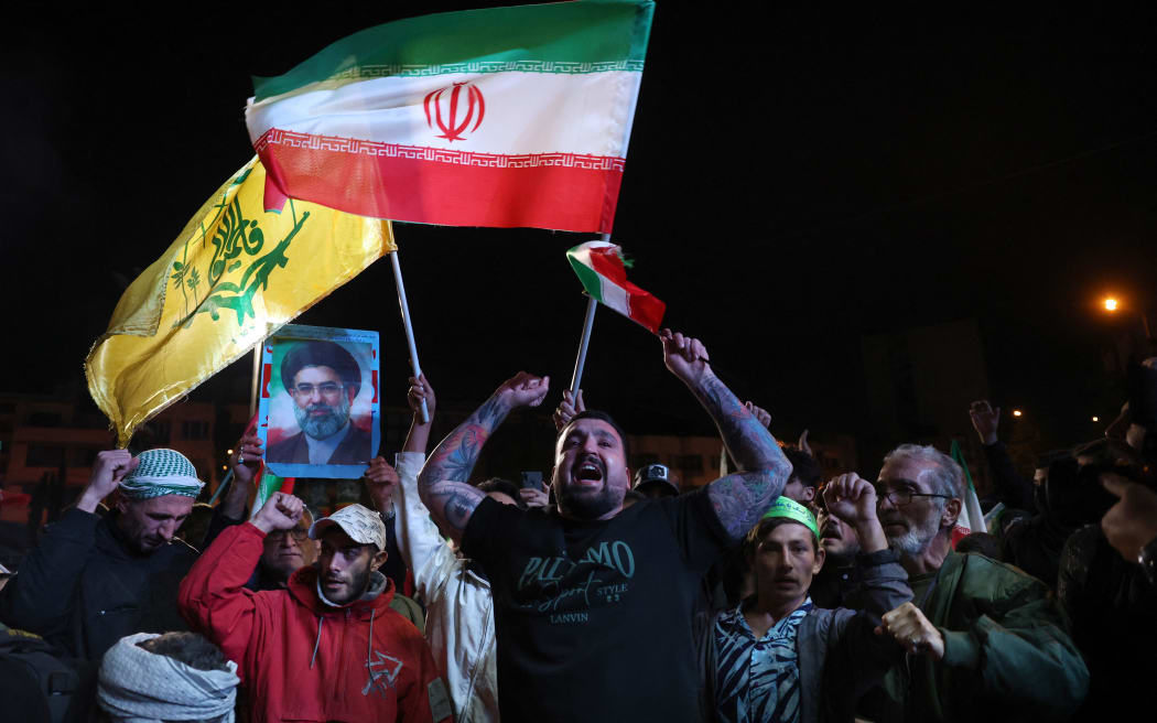 Iranians react after a ceasefire announcement at the Enqelab square, in Tehran, on April 8 2026. The United States and Iran agreed to a two-week ceasefire Tuesday barely an hour before US President Donald Trump's deadline to obliterate the rival country was set to expire, with Tehran to temporarily reopen the vital Strait of Hormuz. (Photo by AFP) /