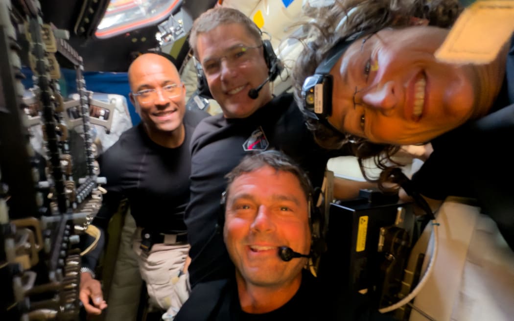 This handout picture released on April 7, 2026, by NASA shows Artemis II crew members (L/R)  Pilot Victor Glover, Mission Specialist Jeremy Hansen, Commander Reid Wiseman, and Mission Specialist Christina Koch taking a selfie together inside the Orion spacecraft on April 6, 2026. The Artemis II astronauts wrapped up their lunar flyby as they continue their journey back to Earth on Tuesday, bringing with them rich celestial observations including little-known lunar craters, a solar eclipse and meteor strikes that scientists hope will open doors. (Photo by HANDOUT / NASA / AFP) / RESTRICTED TO EDITORIAL USE - MANDATORY CREDIT 