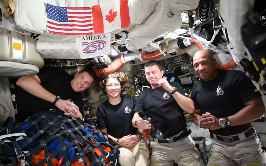 This screengrab from a NASA livestream shows Artemis II crew members Jeremy Hansen, Christina Koch, Reid Wiseman and Victor Glover speaking with US President Donald Trump via a call aboard the Orion spacecraft on April 6, 2026. Artemis astronauts at the outer edge of human space travel had an emotional moment April 6 as they named a crater in honor of the deceased wife of mission commander Reid Wiseman. "It's a bright spot on the Moon. And we would like to call it Carroll," Canadian astronaut Jeremy Hansen told a live broadcast. The crater can be seen "at certain times of the Moon's transit around Earth," he said. (Photo by Handout / NASA / AFP) / RESTRICTED TO EDITORIAL USE - MANDATORY CREDIT "AFP PHOTO / NASA" - HANDOUT - NO MARKETING NO ADVERTISING CAMPAIGNS - DISTRIBUTED AS A SERVICE TO CLIENTS