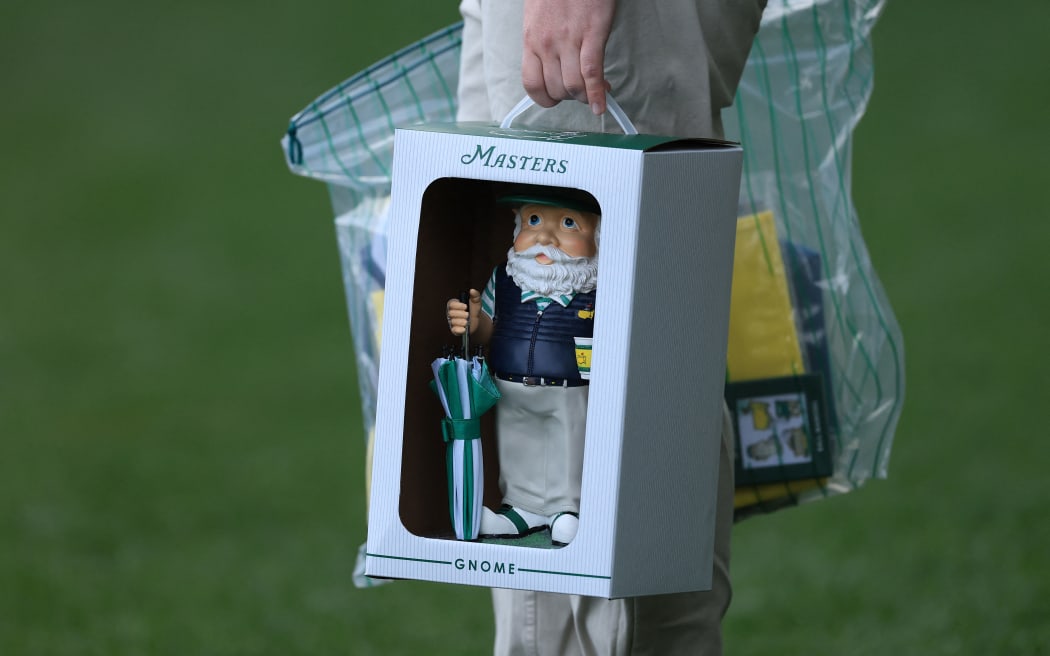 A patron carries the prized purchase of a Masters gnome ahead of this week's major golf tournament at Augusta National in Georgia, April 06, 2026. (Photo by Andrew Redington / GETTY IMAGES NORTH AMERICA / via AFP)