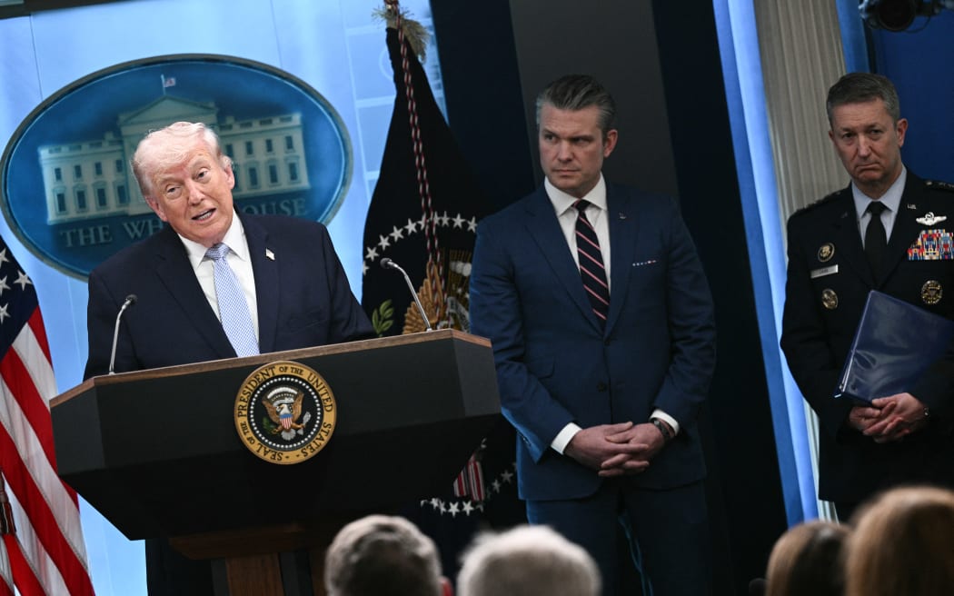 US President Donald Trump, alongside US Secretary of Defense Pete Hegseth (C) and Chairman of the Joint Chiefs of Staff General Dan Caine (R), speaks about the conflict in Iran in the James S. Brady Press Briefing Room of the White House on April 6, 2026, in Washington, DC. (Photo by Brendan SMIALOWSKI / AFP)