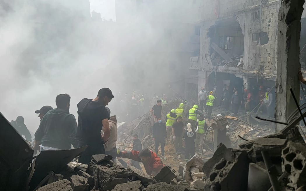 First responders search for survivors at the site of an Israeli strike in Jnah neighbourhood of Beirut on April 5, 2026. An Israeli strike hit south Beirut on April 5, Lebanese state media reported, with a medical source telling AFP it made impact about 100 metres away from a public hospital. The strike hit Beirut's Jnah neighbourhood near Rafik Hariri University Hospital, the largest public medical facility in the country. (Photo by Fadel ITANI / AFP) /