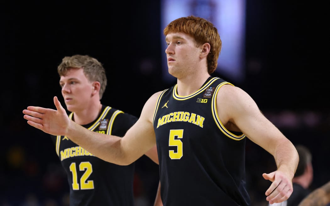 INDIANAPOLIS, INDIANA - APRIL 04: Oscar Goodman #5 of the Michigan Wolverines reacts with teammates after defeating the Arizona Wildcats in the Final Four of the 2026 NCAA Men's Basketball Tournament at Lucas Oil Stadium on April 04, 2026 in Indianapolis, Indiana.   Patrick Smith/Getty Images/AFP (Photo by Patrick Smith / GETTY IMAGES NORTH AMERICA / Getty Images via AFP)