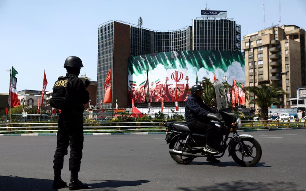 A member of a police force stands guard on a street in Tehran.