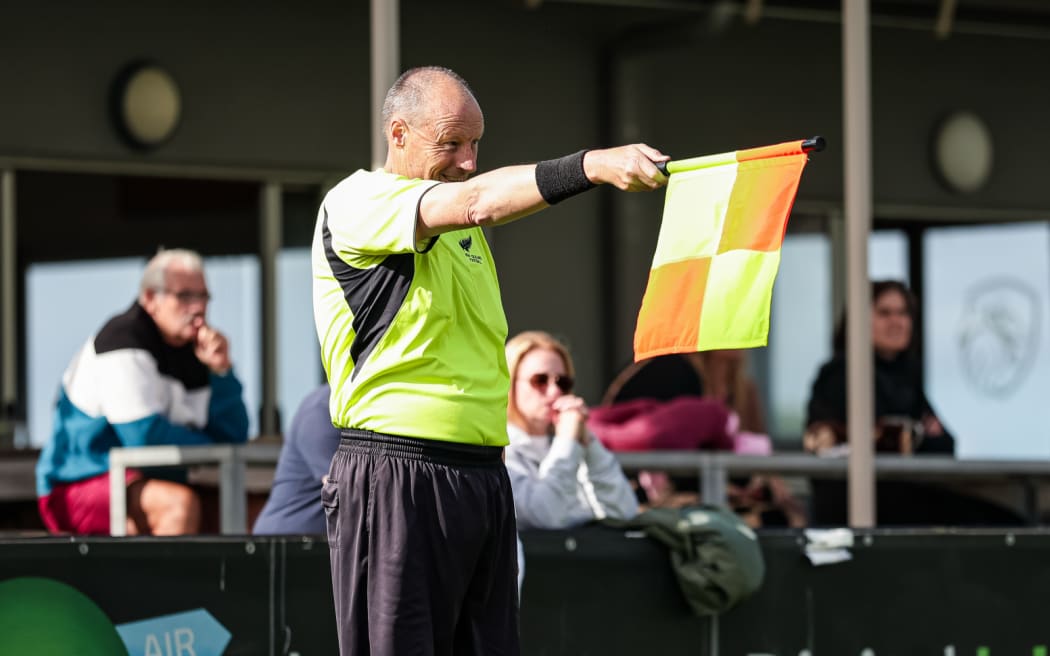 Assistant referee signals offside.