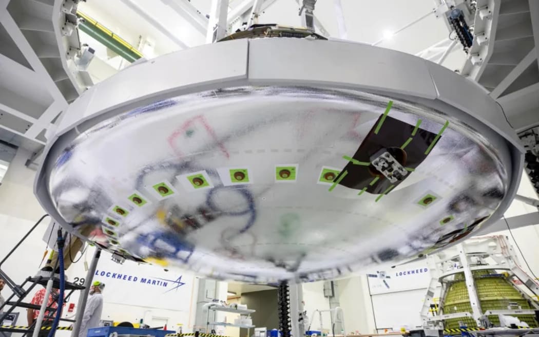 Teams install the heat shield on the Orion spacecraft inside the high bay of the Neil Armstrong Operations and Checkout Building at NASA’s Kennedy Space Center in Florida in June 2023.