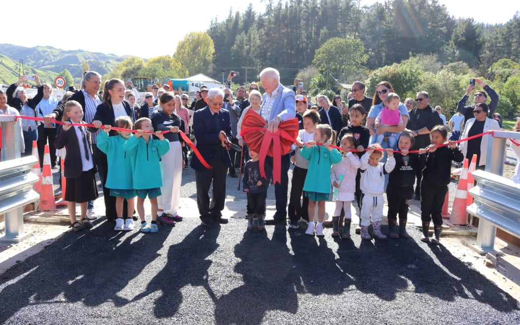 The new permanent Te Reinga Bridge was officially opened with a ribbon-cutting on Thursday. Holding the scissors is local kaumātua Ereatara Tutehuinga NiaNia (Eric), along with Mayor Craig Little, local woman Chrissy Sainsbury, local MP Katie Nimon and local rangatahi.