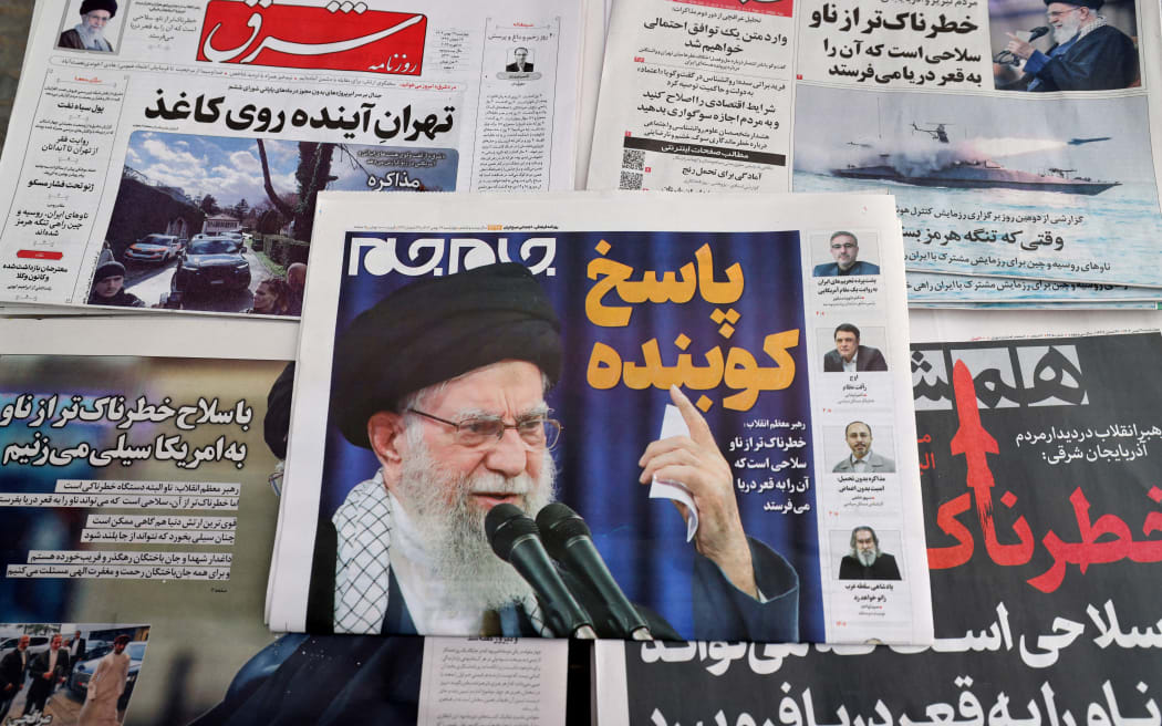 Daily Iranian newspapers are fronted with the image of Iran's Supreme Leader Ayatollah Ali Khamenei and other headlines,  displayed at a kiosk in Tehran on February 18, 2026. Iran said February 17, 2026, it had agreed with the United States in talks in Geneva on "guiding principles" for a deal to avoid conflict, but the US Vice President said Tehran had not yet acknowledged all of Washington's red lines. (Photo by ATTA KENARE / AFP)