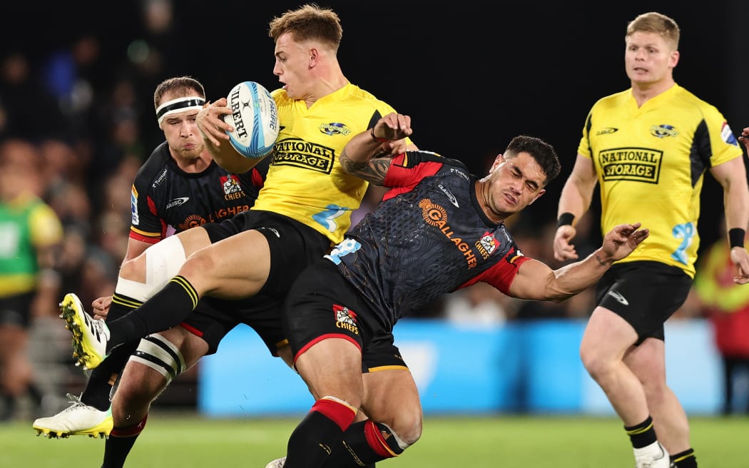 Ruben Love of the Hurricanes and Quinn Tupaea of the Chiefs battle for the ball.
