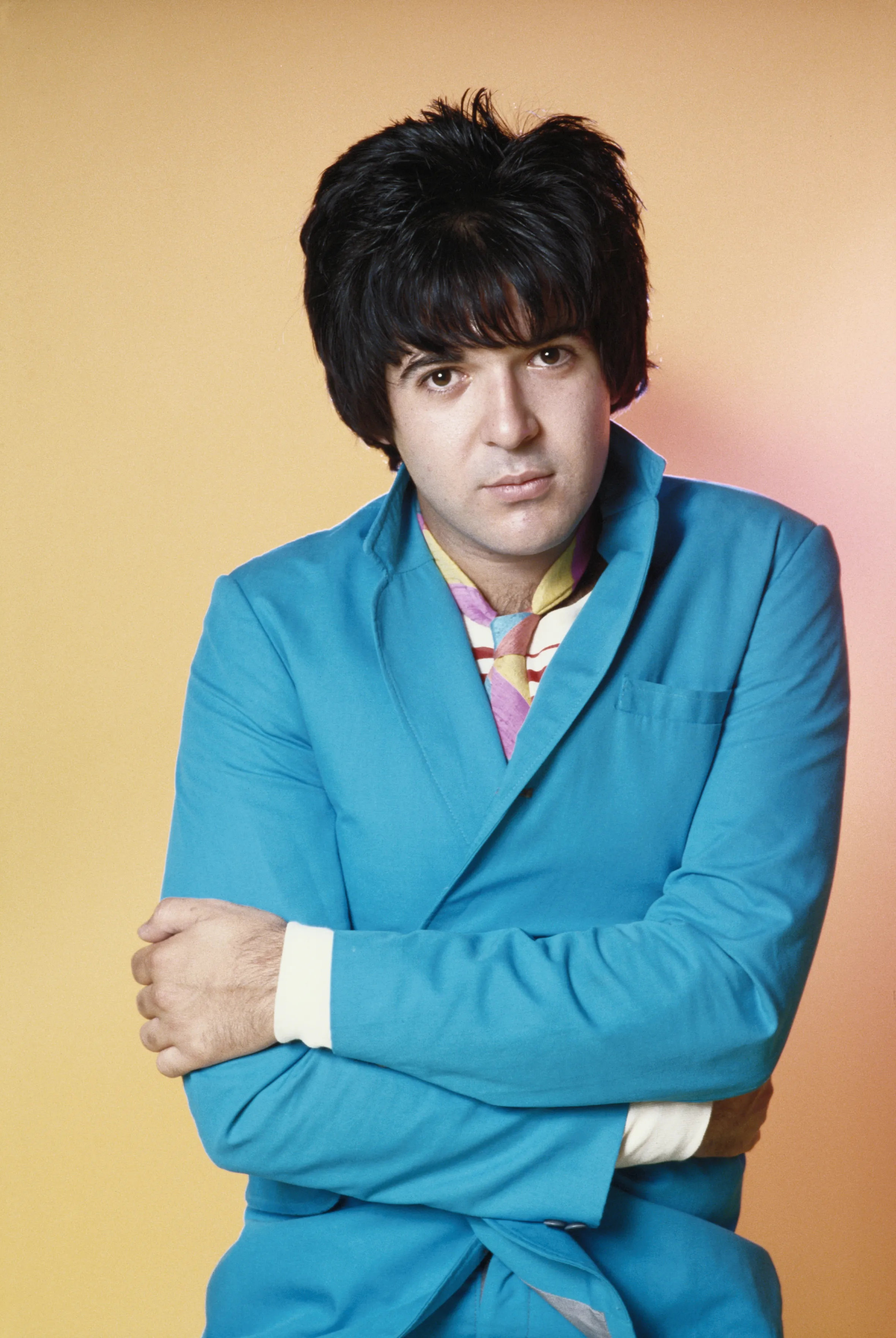 Clem Burke of Blondie, circa 1979, wearing a bright blue jacket and colorful striped tie.