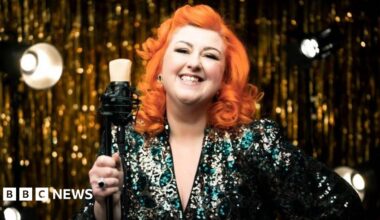 Michelle McManus, with bright orange hair wearing a sequin dress.