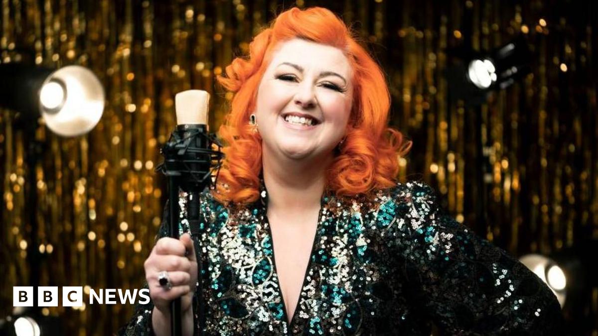 Michelle McManus, with bright orange hair wearing a sequin dress.