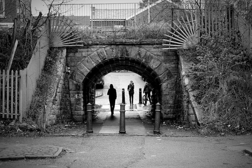 People walking through an underpass.