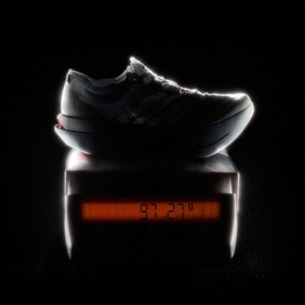 Adidas adizero pro 3 launch shoe silhouette on a scale displaying its weight
