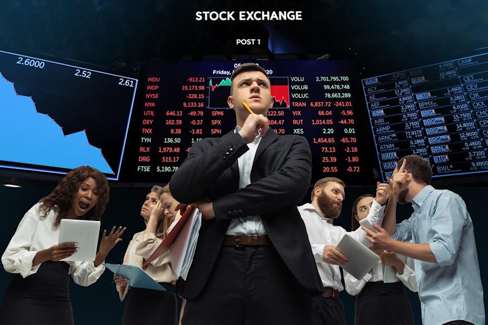 Investors at a stock exchange considering stocks to buy on the dip.