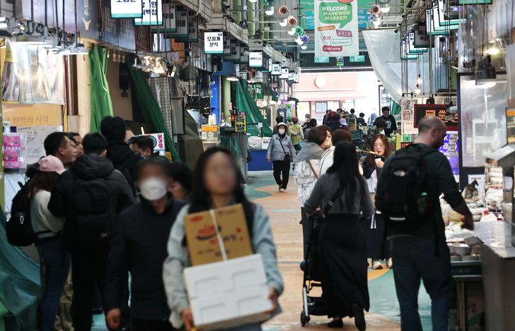 Vendors and customers are seen at a traditional market in Mapo District, Seoul, Tuesday. Yonhap