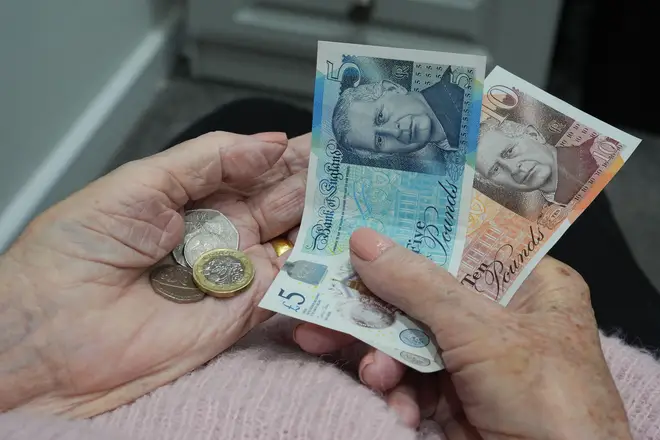 Picture posed by model File photo dated 13/01/25 of an old age pensioner holding bank notes and coins at home in Essex.