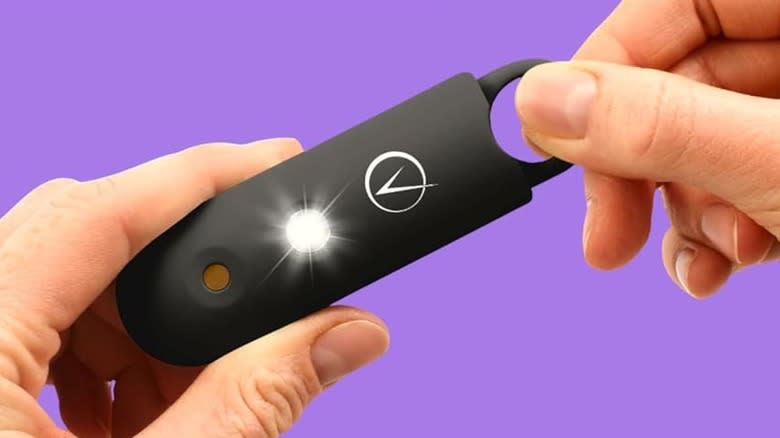 A hand pulling on the pin of the Vantamo personal alarm.