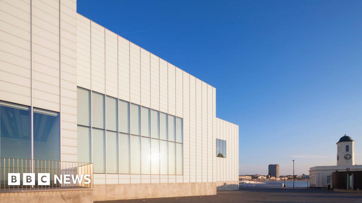 The image shows the outside of an art gallery against a deep blue sky.