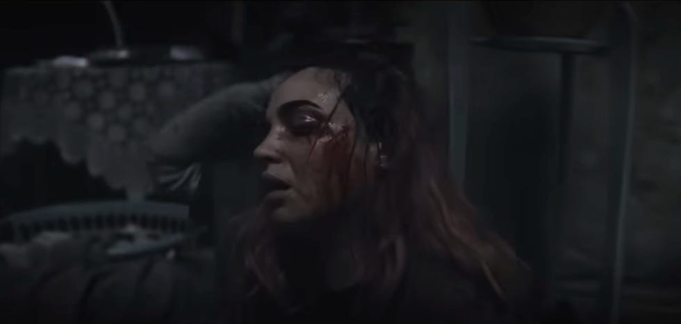 a person with obscured facial features in a dimly lit environment