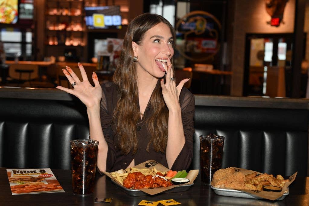 In this image released on March 27th,  Amanda Batula searches for the perfect Pick 6 date at Buffalo Wild Wings in Wayne, New Jersey. (Photo by Dave Kotinsky/Getty Images for Buffalo Wild Wings)