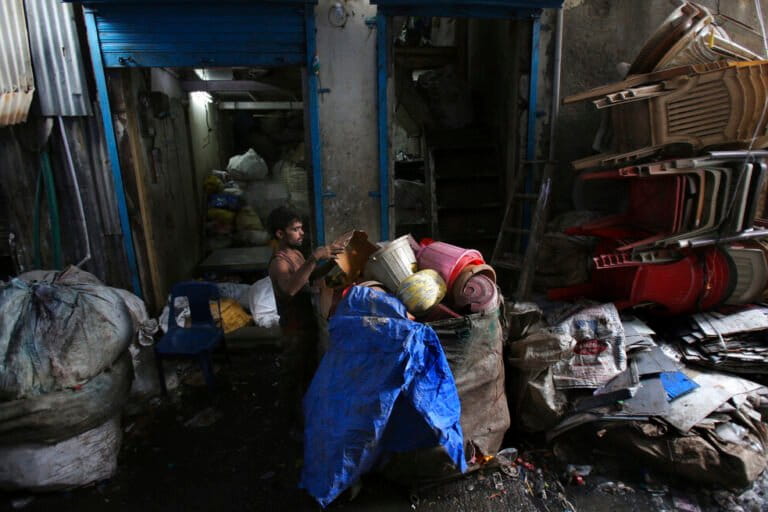 A worker sorts used plastic at a recycling unit in Mumbai. (AP Photo/Rafiq Maqbool)