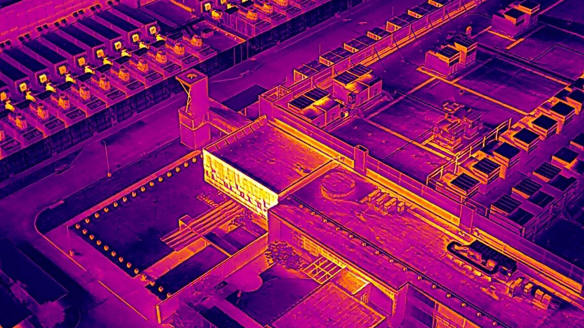 A data center in Garland, Texas as seen through a drone's thermal imaging camera that primarily displays purple, orange, red and yellow colors to show heat signature.