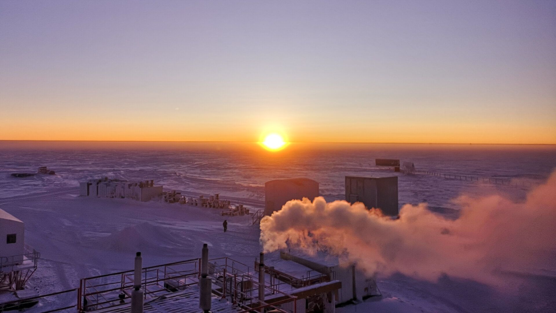sun is low on the horizon and glowing a deep orange yellow.
