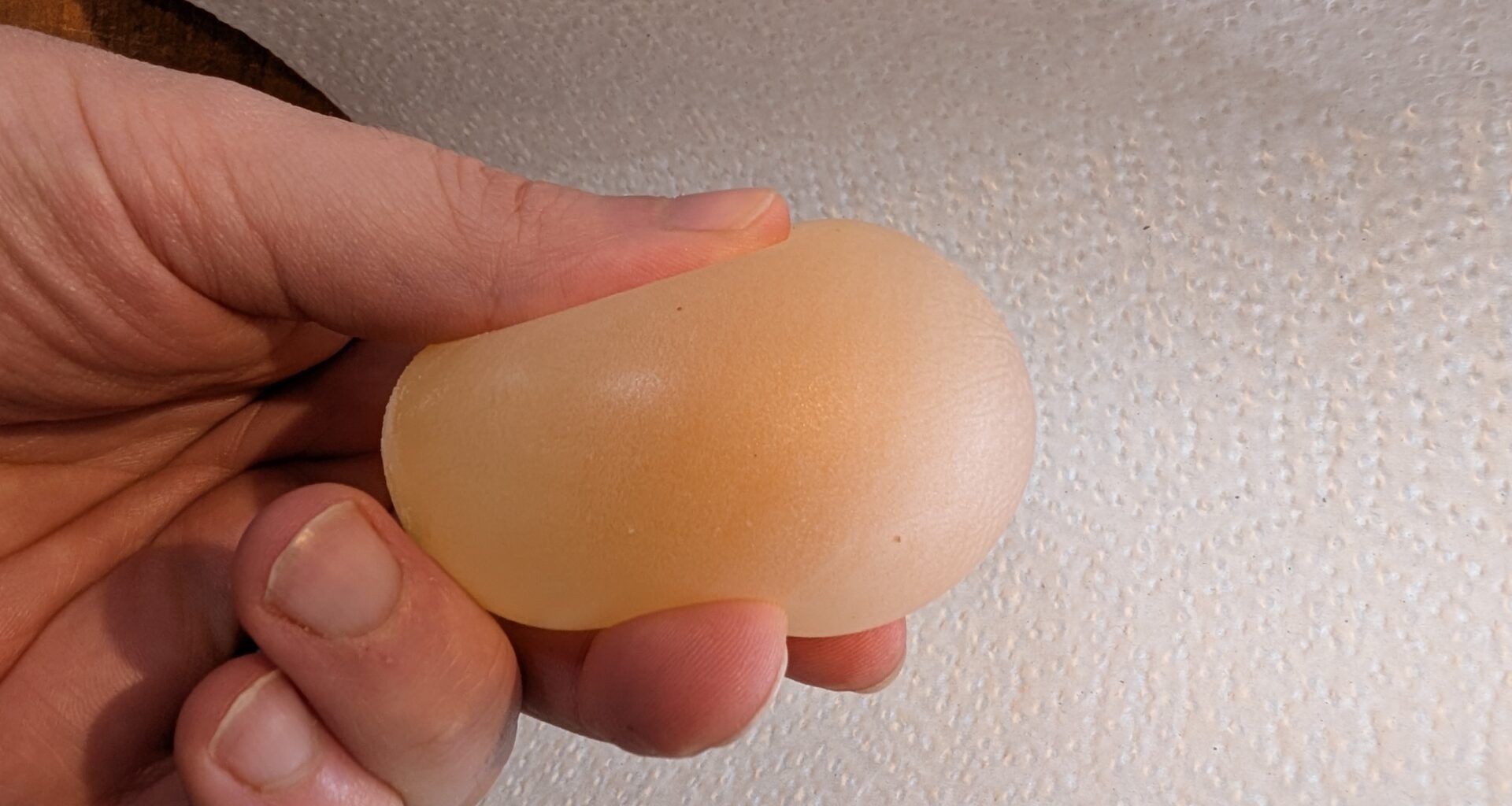 A hand holds and squeezes a dissolved egg