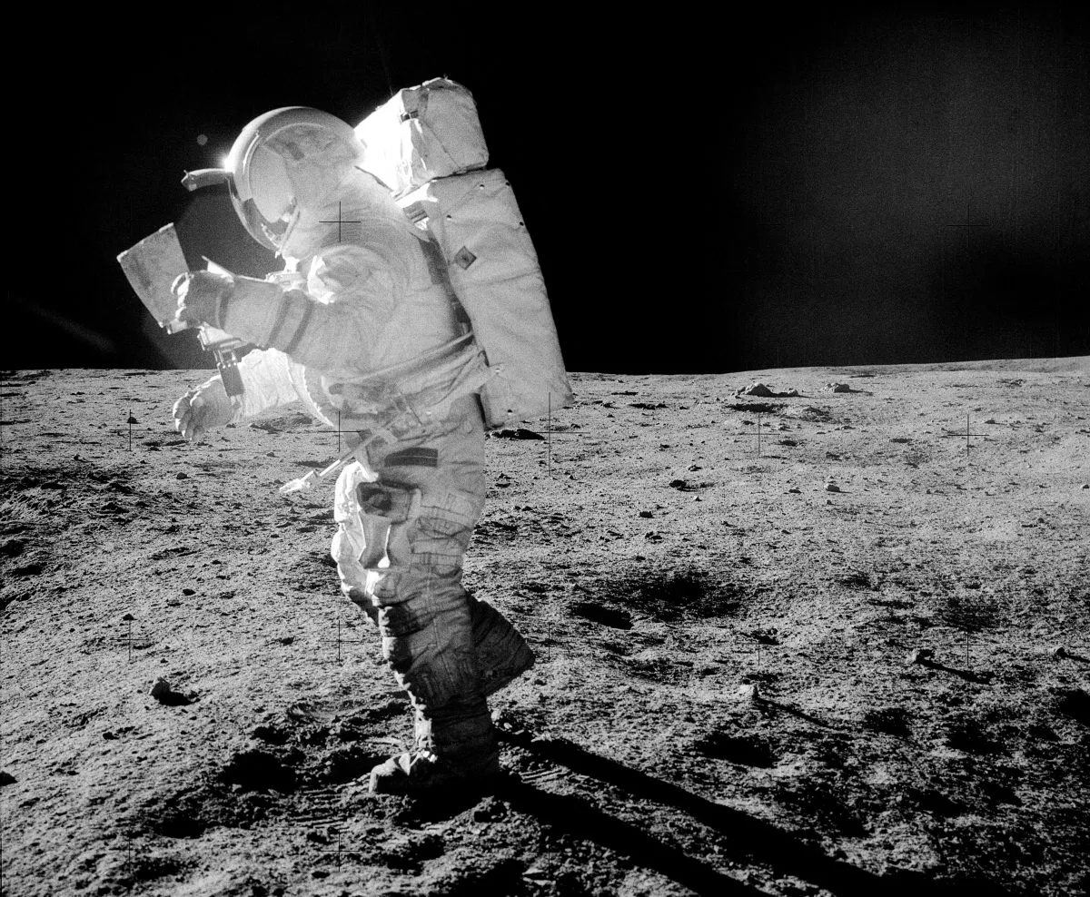 Astronaut Edgar Mitchell on the surface of the Moon during Apollo 14. Mitchell is seen studying a traverse map during exploration of Fra Mauro. Note the lunar dust clinging to Mitchell's boots and legs. Credit: NASA/Alan Shepard