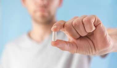 Man Holding White Capsule Supplement Pill
