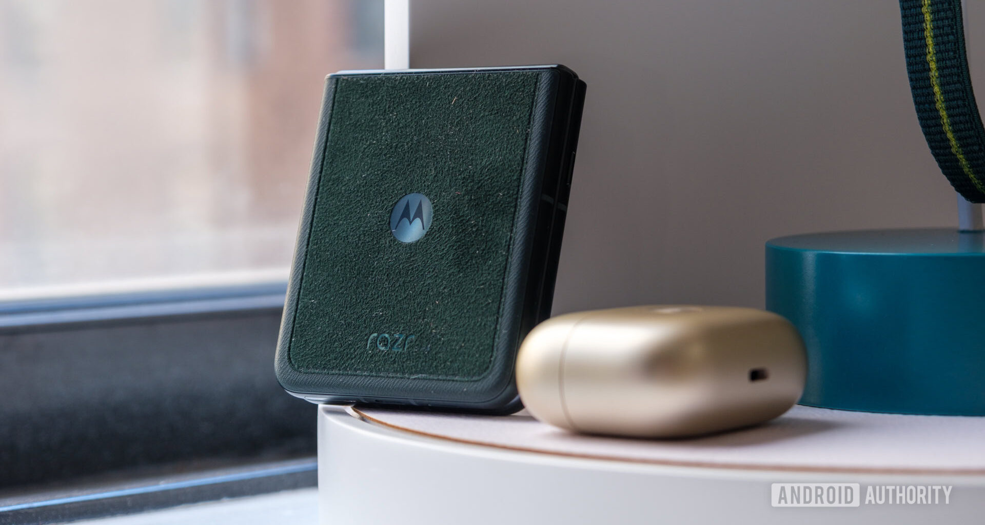 Motorola Razr Ultra in Alcantera next to Moto Loop Buds