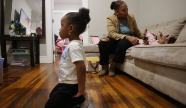 Brianna Smith-Thomson, a 35-year-old mother of three, played with her 5-month-old daughter, Serenity, on the couch as her other daughter, Heavyn, 4, watched television in the family’s living room in Lynn.