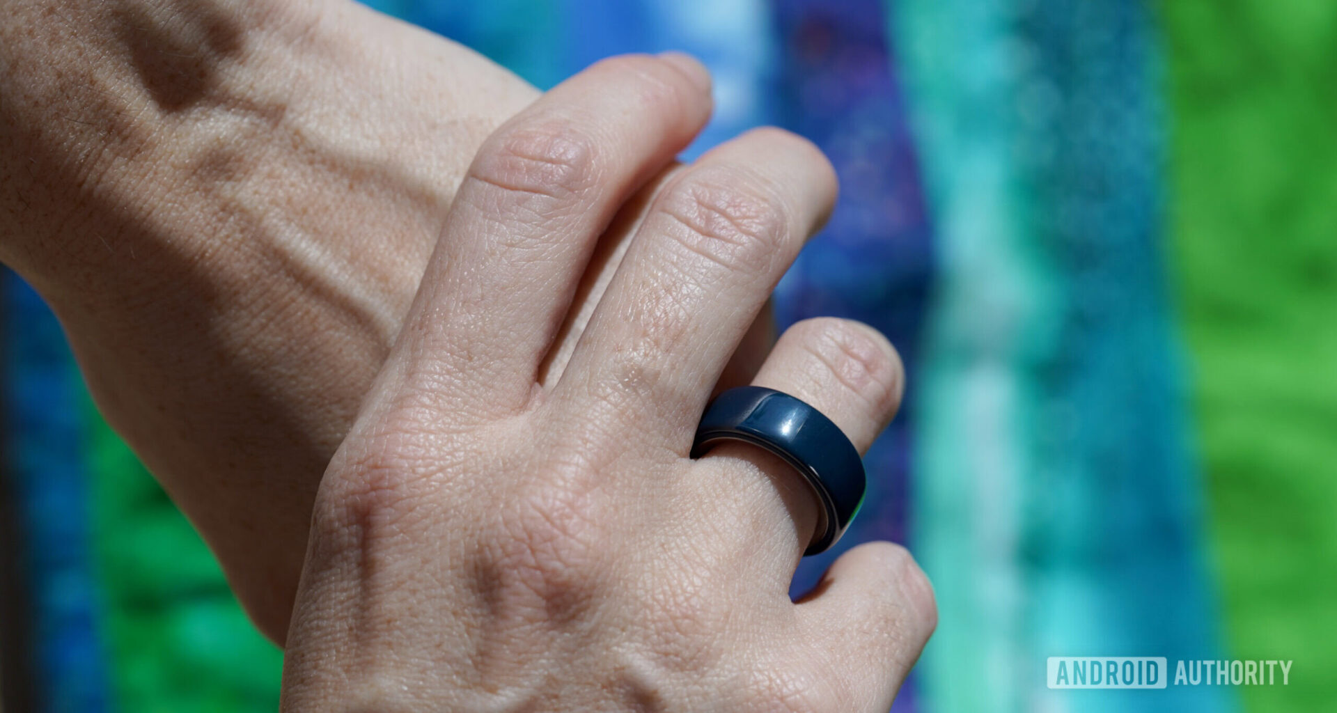An Oura Ring user wears a ceramic model in Midnight.