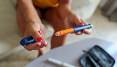 Unrecognizable middle-aged woman preparing an insulin pen to inject herself with a dose.