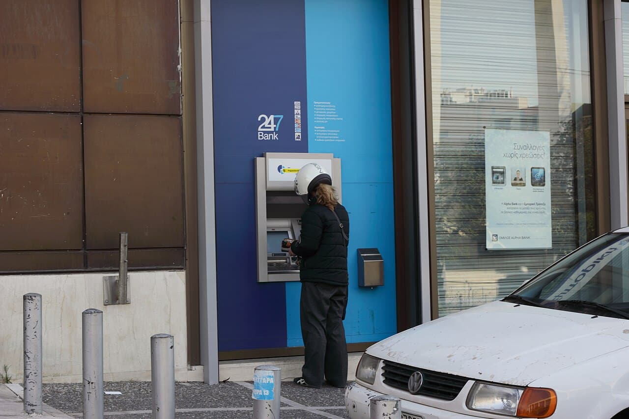 Person uses a bank's ATM in Greece
