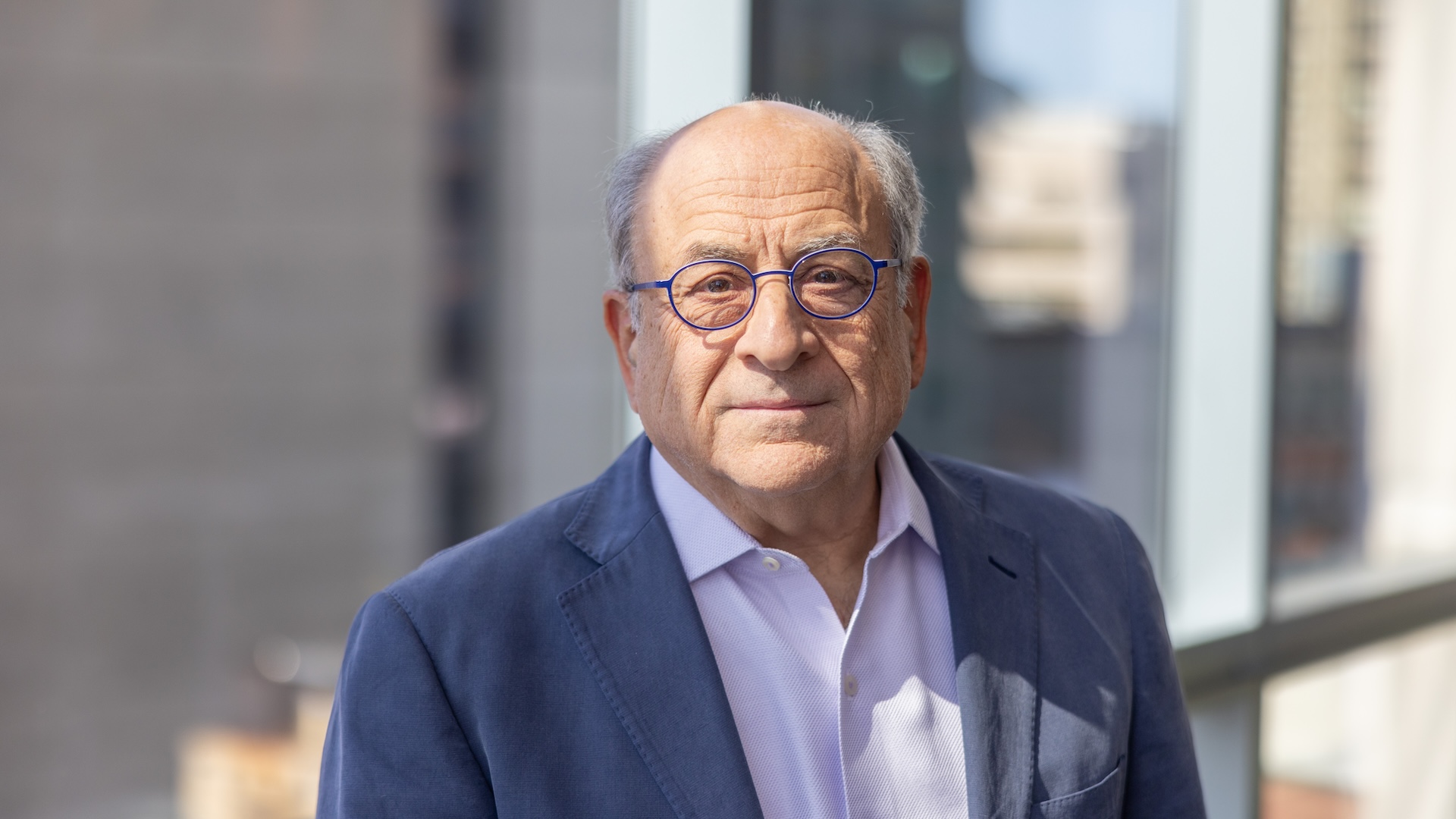horizontal headshot of Stuart Orkin with buildings in background
