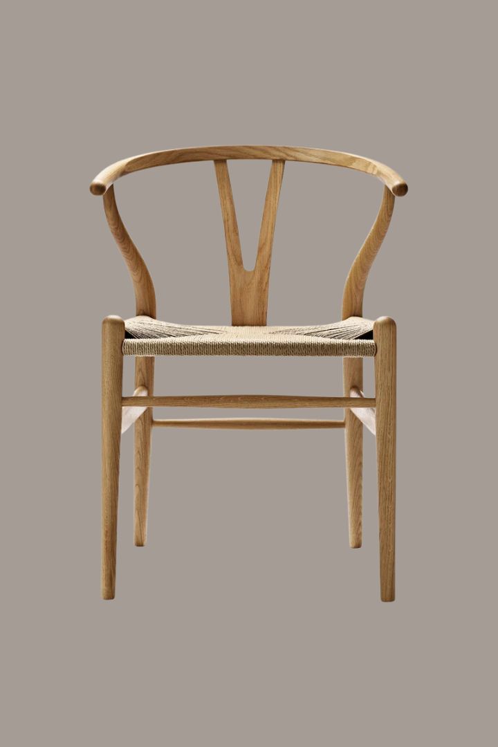 Wooden chair placed against pale brown background.