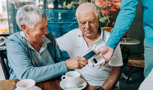 A couple at paying for drinks at a cafe