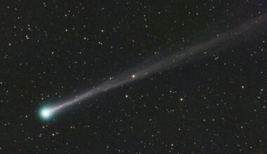 a comet with a long tail and a green blue head.