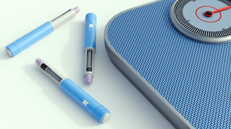 a light blue medical injector pen and a bathroom scale