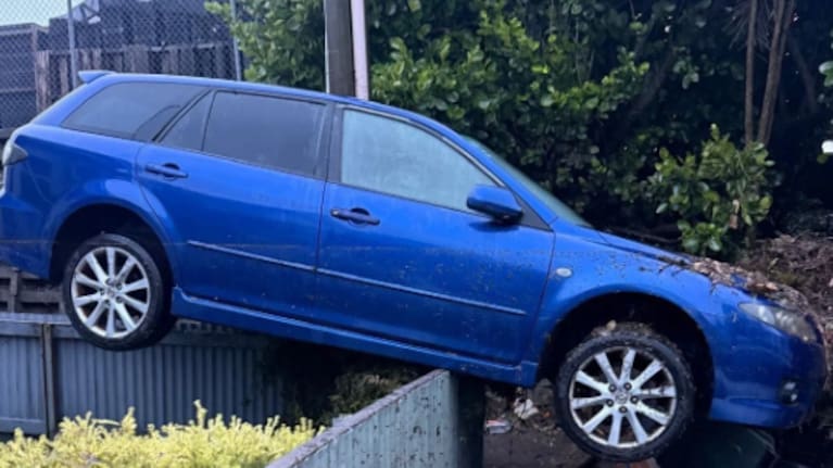 A car lifted onto a fence by floodwater in Emerson St, Berhampore