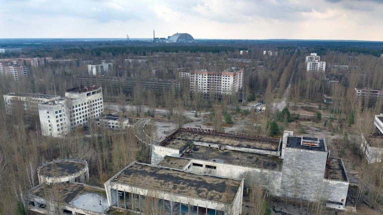 A dome-shaped shelter covering the damaged reactor at the Chernobyl nuclear plant is seen on the horizon, April 15, 2021.