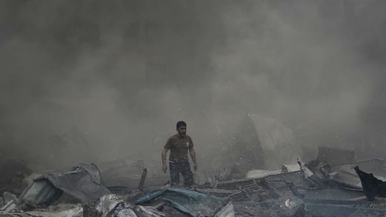 A first responder emerges through the smoke at the site of an Israeli airstrike that struck an apartment building in Beirut, Lebanon.
