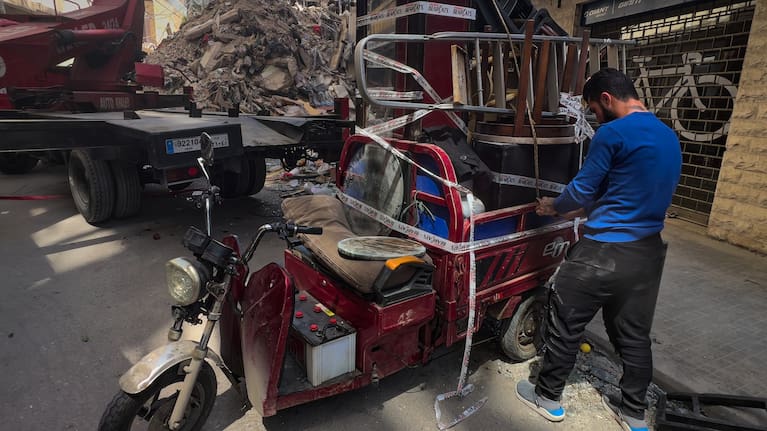 A worker arranges furniture from an apartment of a destroyed building that was hit a week ago in an Israeli airstrike in central Beirut, Lebanon.