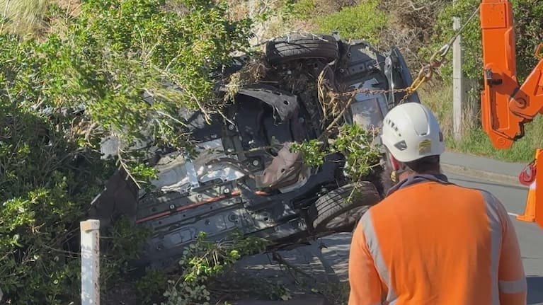 A wrecked car is pulled from the Ōwhiro Stream.