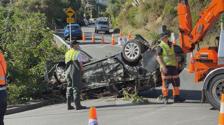 A wrecked car is pulled from the Ōwhiro Stream.