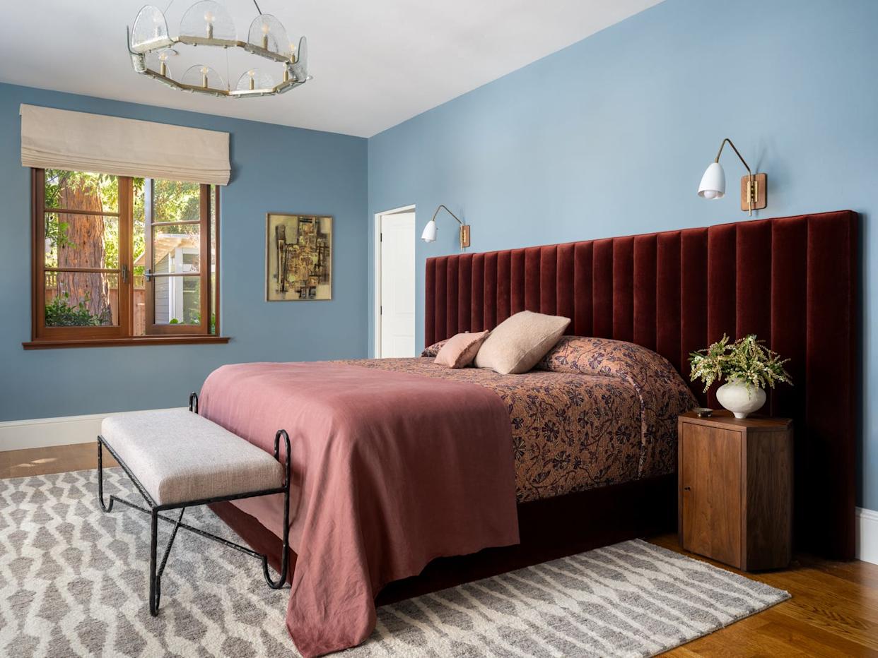 Bedroom featuring a velvet headboard, bench, and decorative elements.